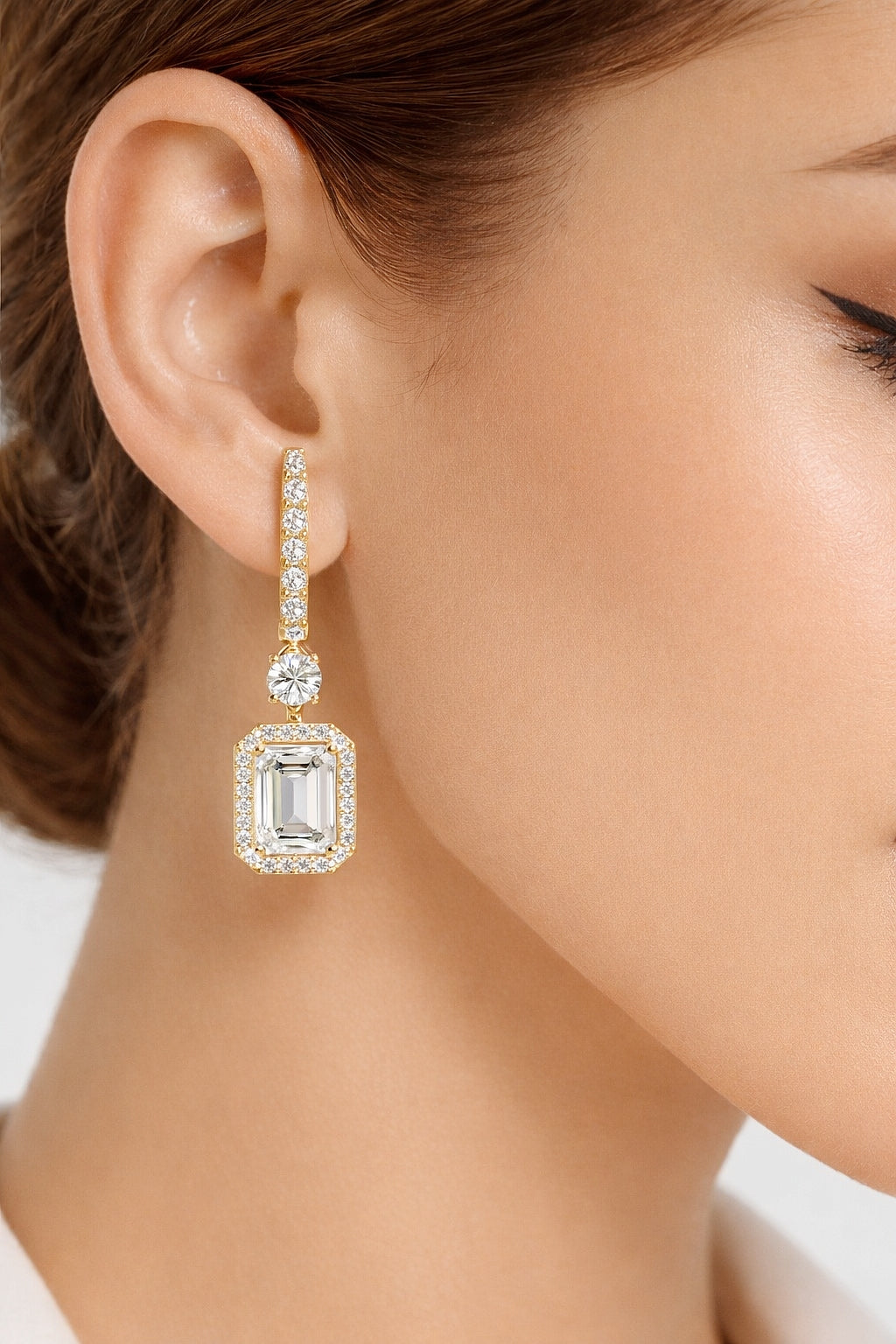 Rose gold halo drop earrings with emerald cut center stones worn look