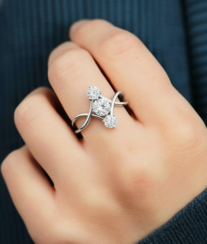 Hand wearing round cut three stone diamond ring with open infinity band style